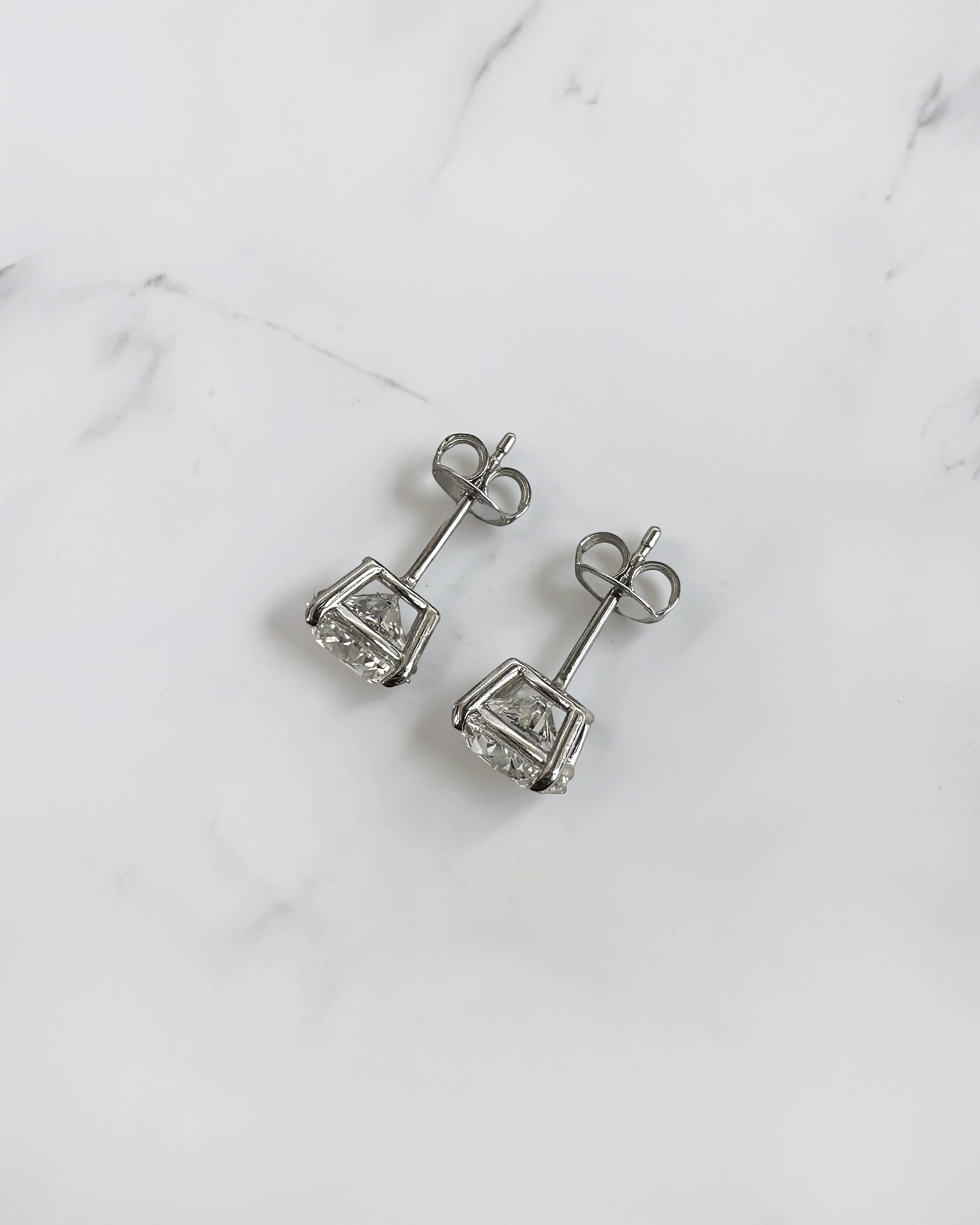 4ct round brilliant lab grown diamond stud earrings featuring 2ct E/F VS1+ lab grown diamonds with Ideal Cut, Excellent Polish, Excellent Symmetry and No Fluorescence in a four prong basket setting.