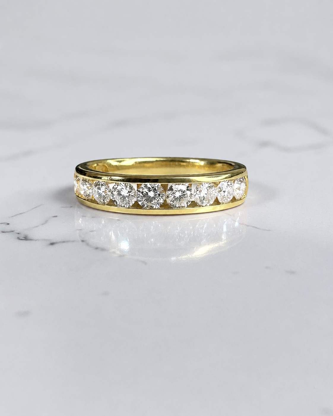 4mm channel set round diamond wedding band in yellow gold featuring 0.80ct of round brilliant diamonds set halfway around the band.