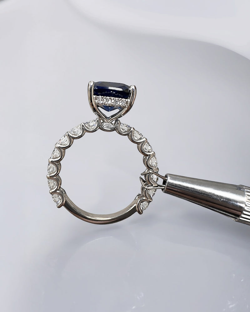 5.50ct cushion cut lab grown blue sapphire engagement ring with diamond hidden halo and 1.60ct lab grown diamond band in platinum.