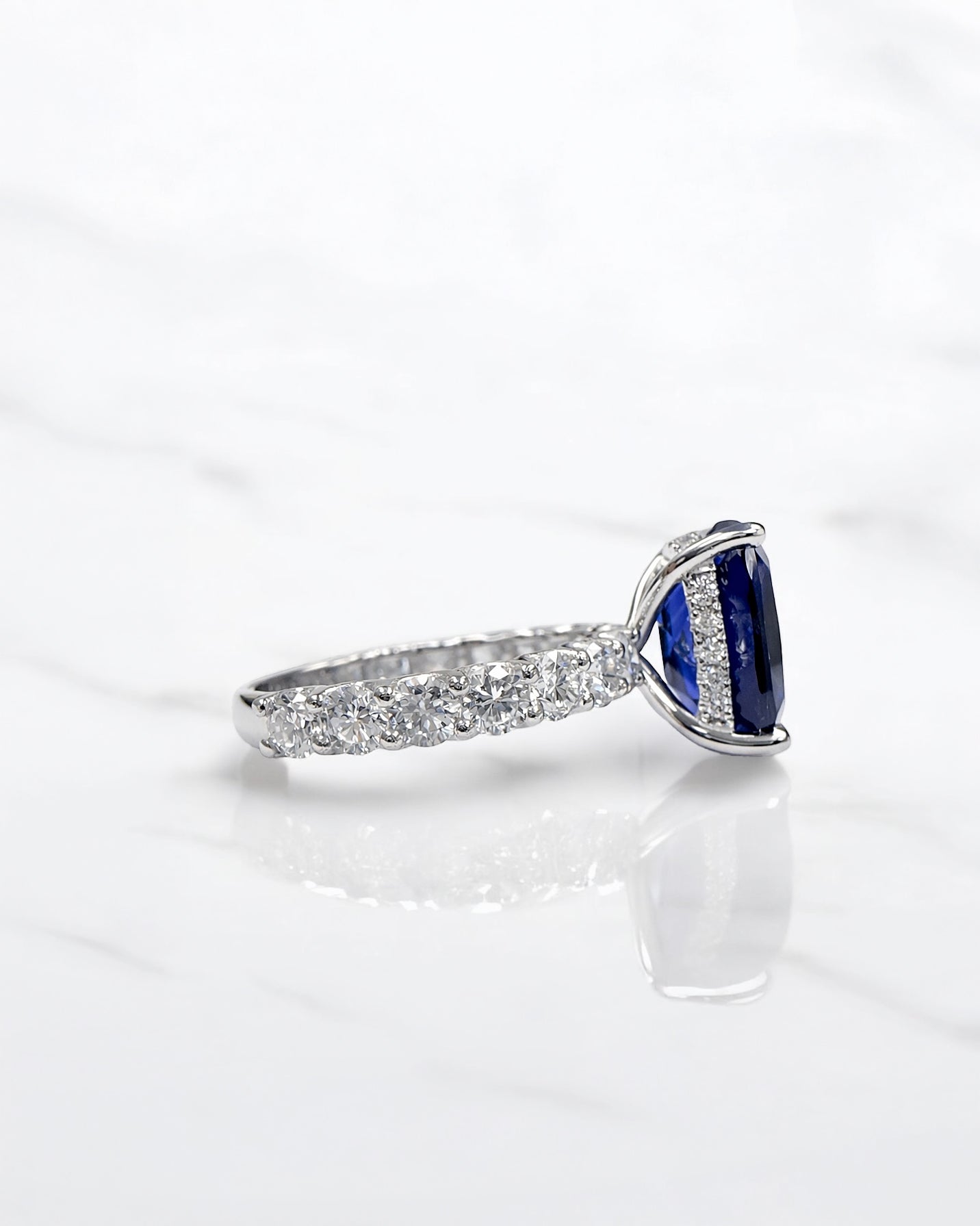 5.50ct cushion cut lab grown blue sapphire engagement ring with diamond hidden halo and 1.60ct lab grown diamond band in platinum.
