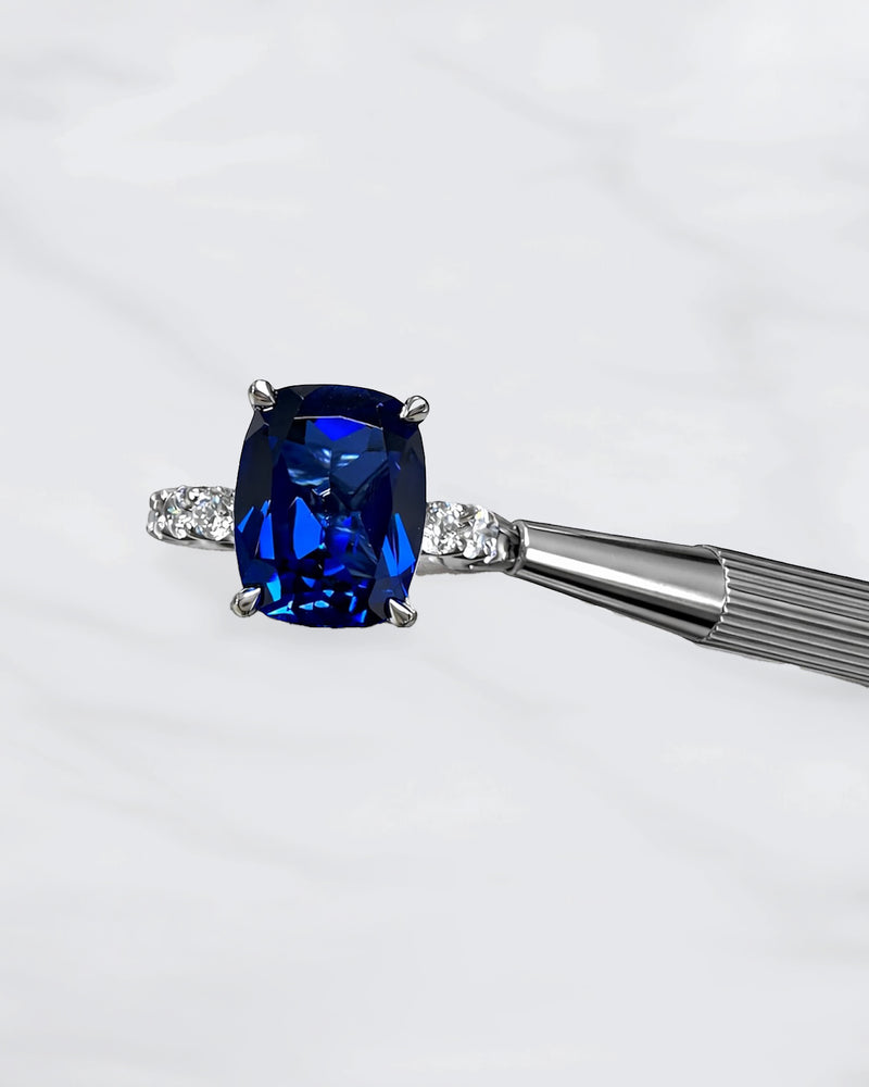 5.50ct cushion cut lab grown blue sapphire engagement ring with diamond hidden halo and 1.60ct lab grown diamond band in platinum.
