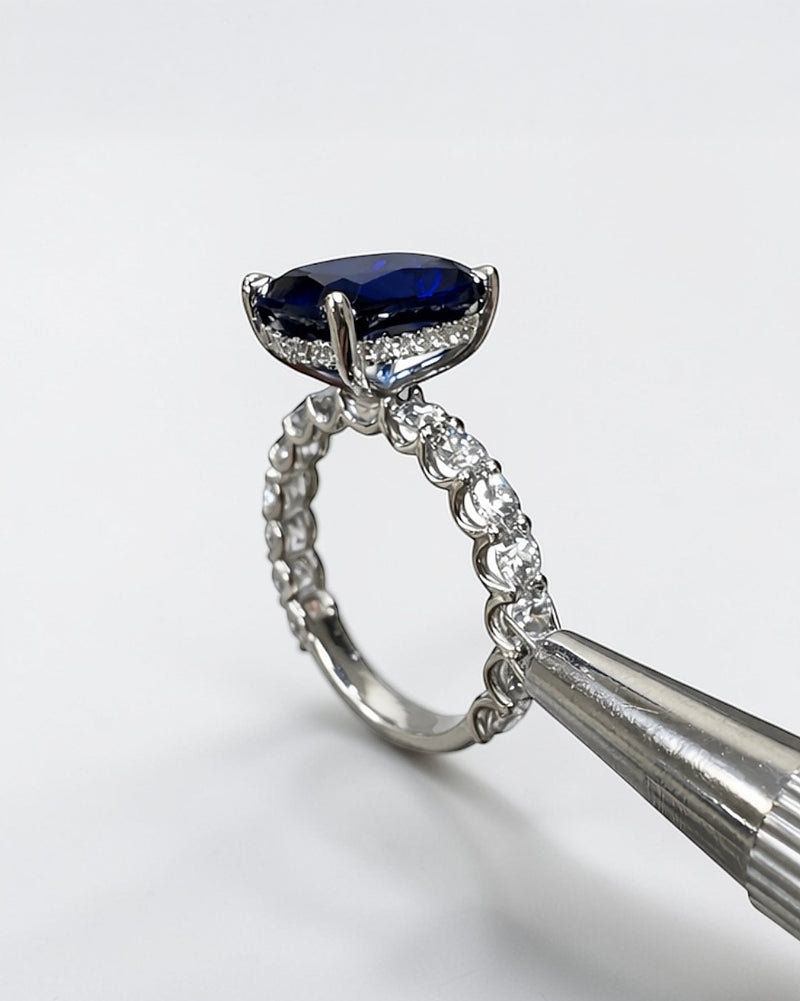 5.50ct cushion cut lab grown blue sapphire engagement ring with diamond hidden halo and 1.60ct lab grown diamond band in platinum.