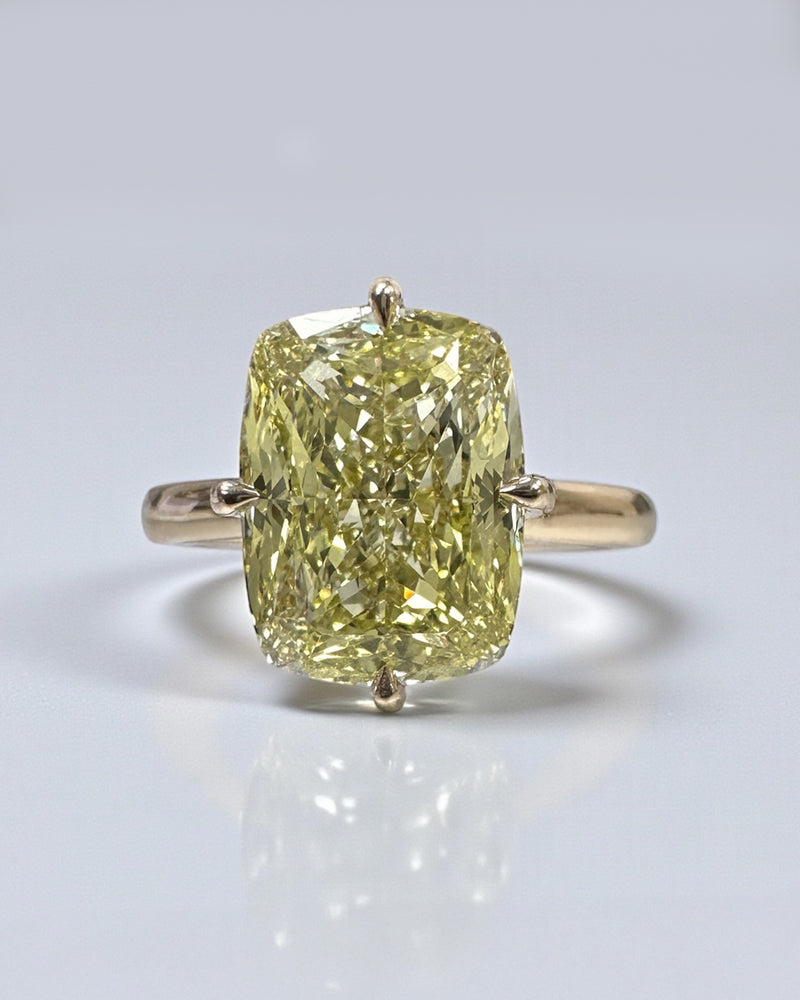 A stunning 5ct Fancy Intense Yellow elongated cushion cut diamond solitaire with platinum hidden halo and 18kt yellow gold band engagement ring. Bold, elegant and handcrafted in London.