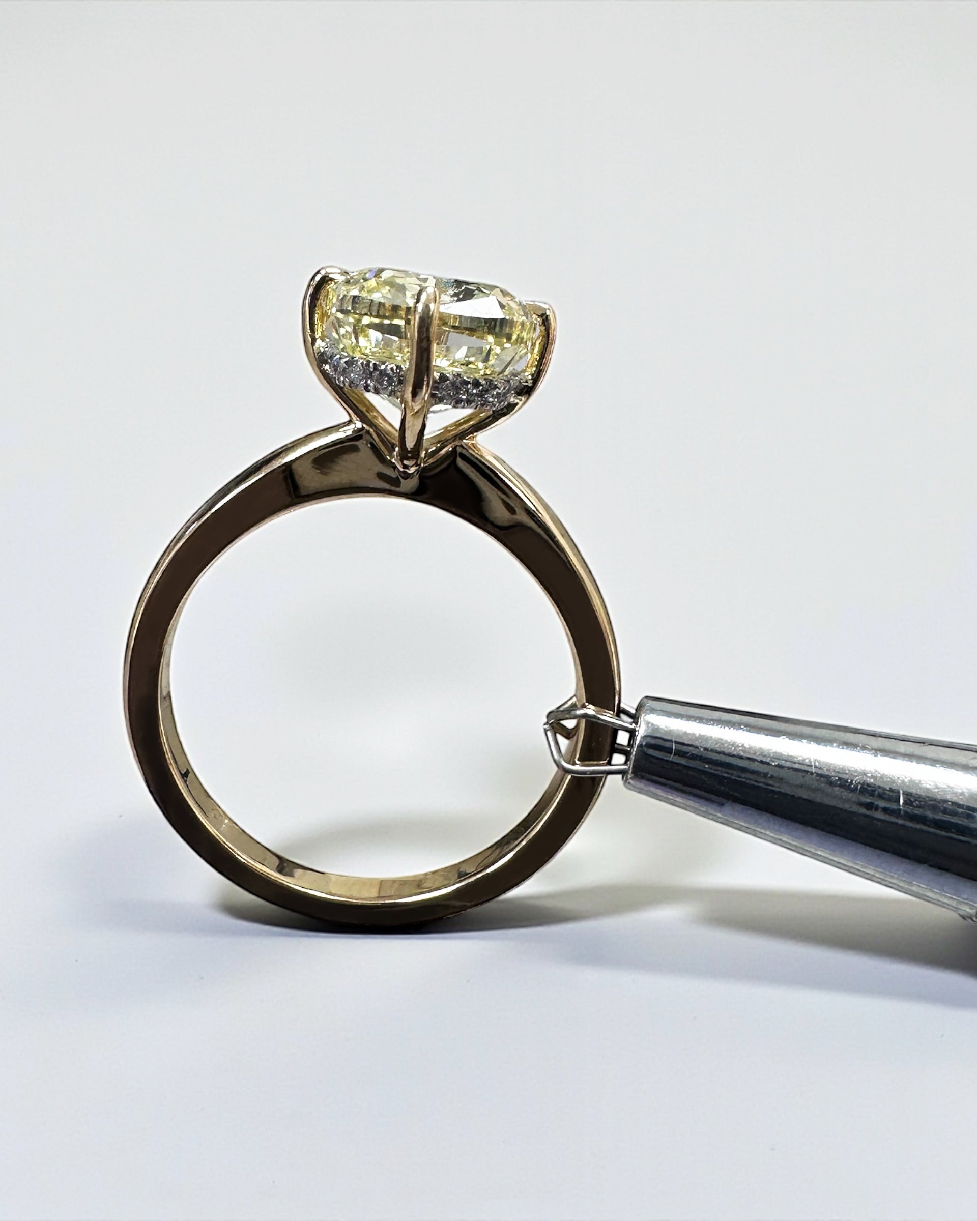 A stunning 5ct Fancy Intense Yellow elongated cushion cut diamond solitaire with platinum hidden halo and 18kt yellow gold band engagement ring. Bold, elegant and handcrafted in London.