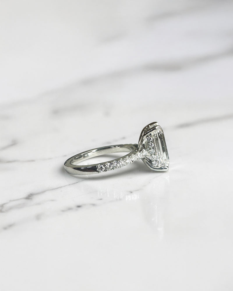 5ct emerald cut lab grown diamond engagement ring with cathedral setting, diamond shoulders, hidden halo and 5.45ct total diamonds by Layla Diamonds.