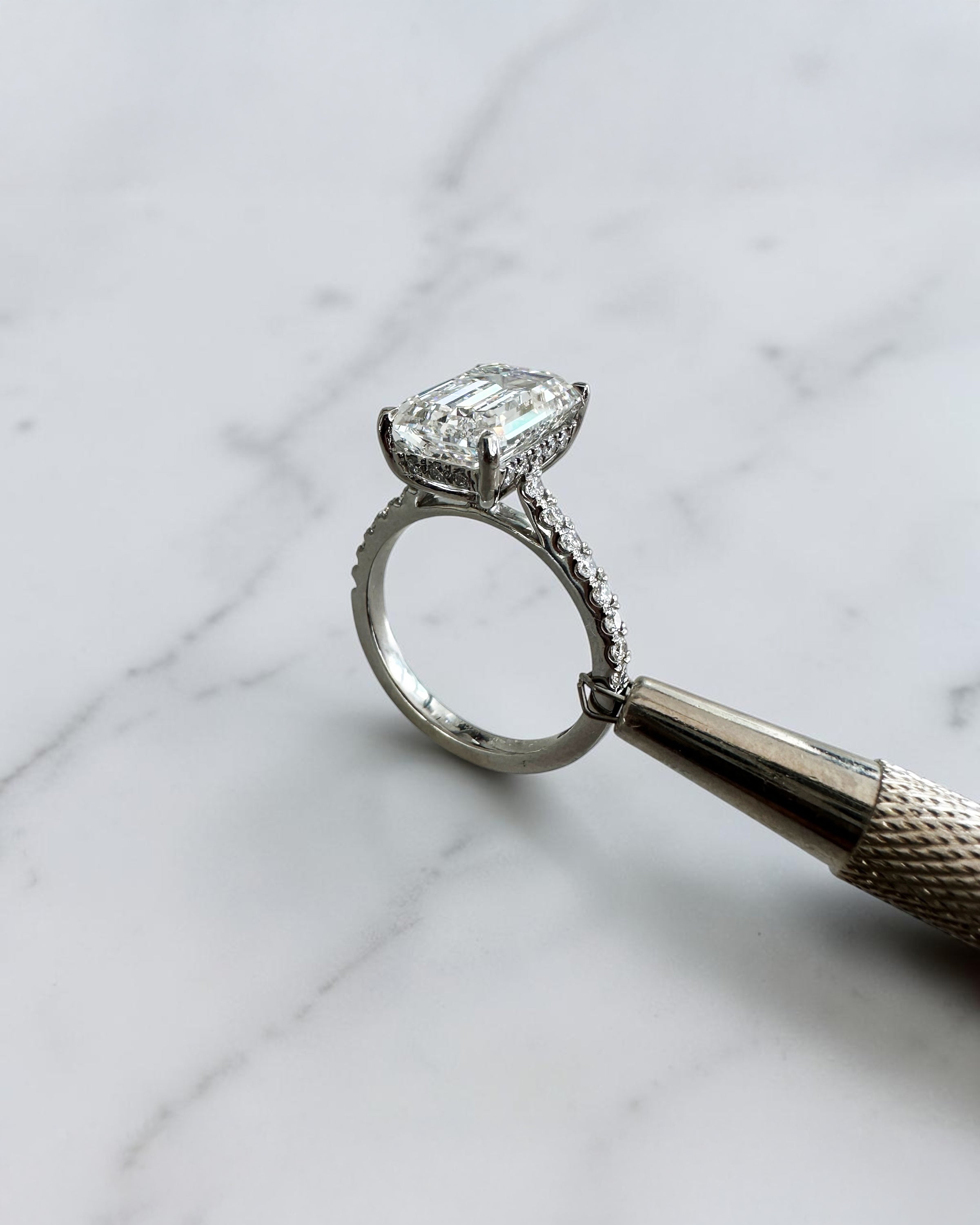 5ct emerald cut lab grown diamond engagement ring with cathedral setting, diamond shoulders, hidden halo and 5.45ct total diamonds by Layla Diamonds.