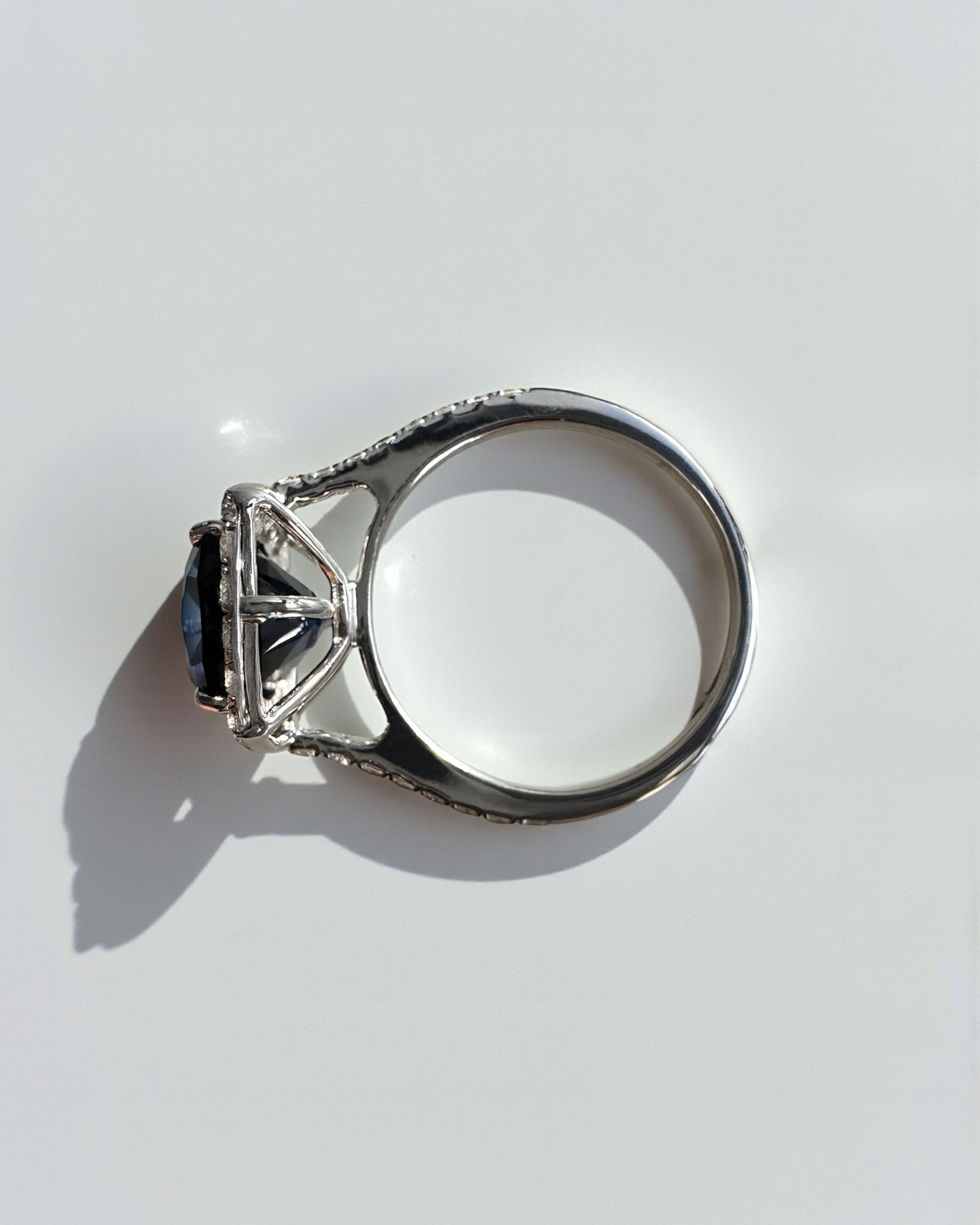 Striking 5ct lab grown blue sapphire halo diamond ring with diamond shoulders. Available in 9kt or 18kt gold or platinum. Made to order. Layla Diamonds London