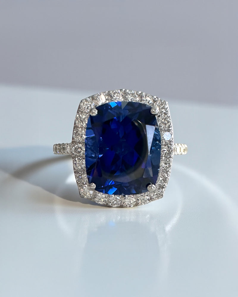 Striking 5ct lab grown blue sapphire halo diamond ring with diamond shoulders. Available in 9kt or 18kt gold or platinum. Made to order. Layla Diamonds London