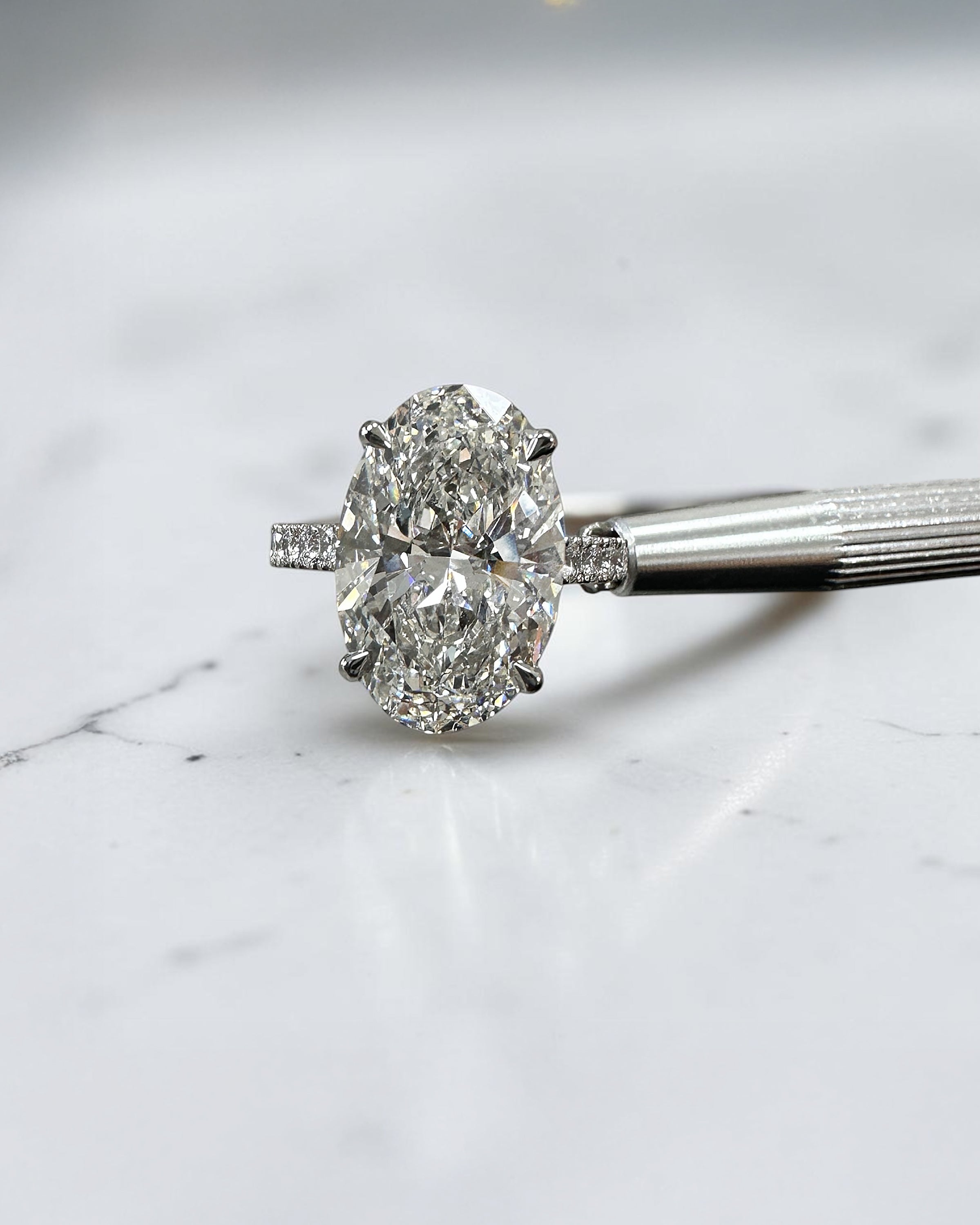 6ct oval cut lab grown diamond engagement ring with cathedral setting, diamond shoulder scallop band, diamond wrap hidden halo and diamond bridge. Handmade in London and available in platinum, 18ct yellow gold, white gold or rose gold.

