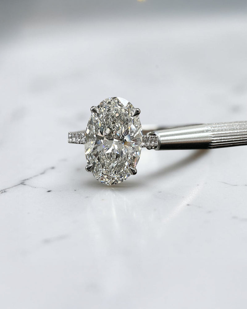 6ct oval cut lab grown diamond engagement ring with cathedral setting, diamond shoulder scallop band, diamond wrap hidden halo and diamond bridge. Handmade in London and available in platinum, 18ct yellow gold, white gold or rose gold.
