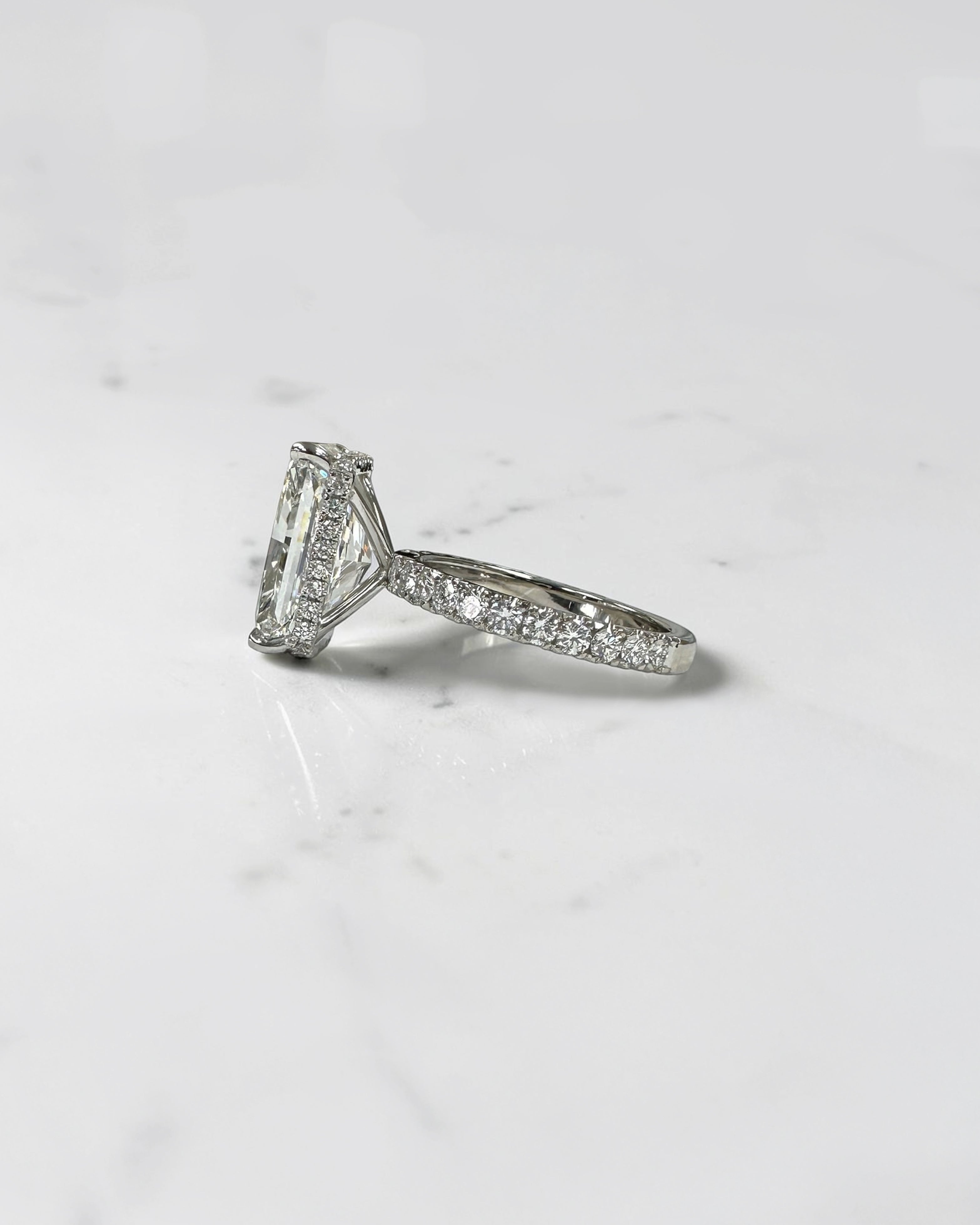 7ct radiant cut lab grown diamond engagement ring with diamond shoulder band, floating setting and wrap around hidden halo, handmade in London.