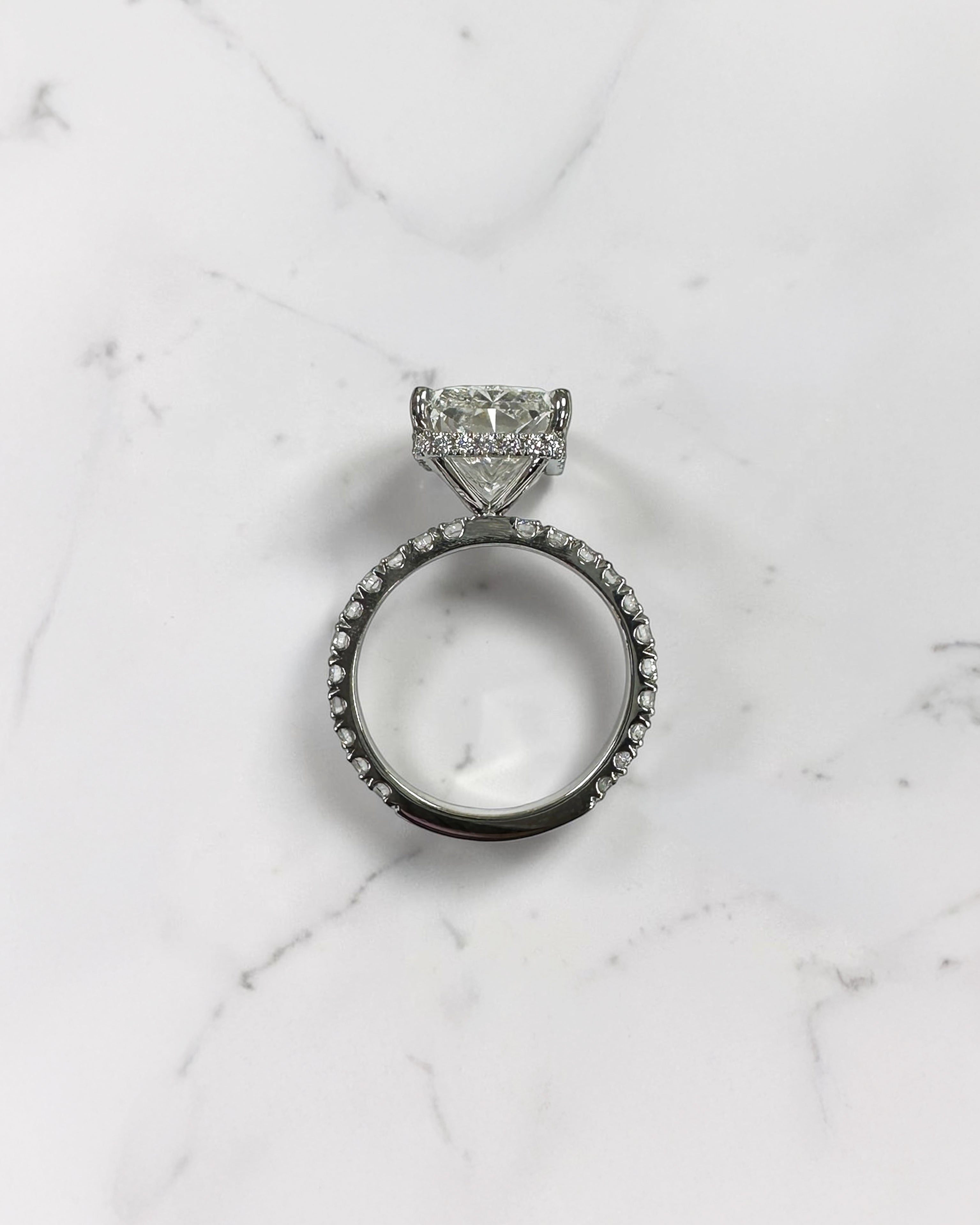 7ct radiant cut lab grown diamond engagement ring with diamond shoulder band, floating setting and wrap around hidden halo, handmade in London.