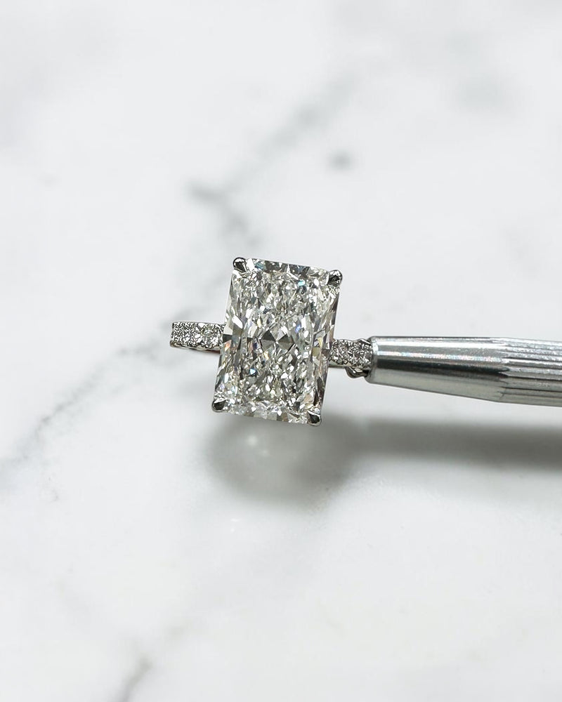 7ct radiant cut lab grown diamond engagement ring with diamond shoulder band, floating setting and wrap around hidden halo, handmade in London.