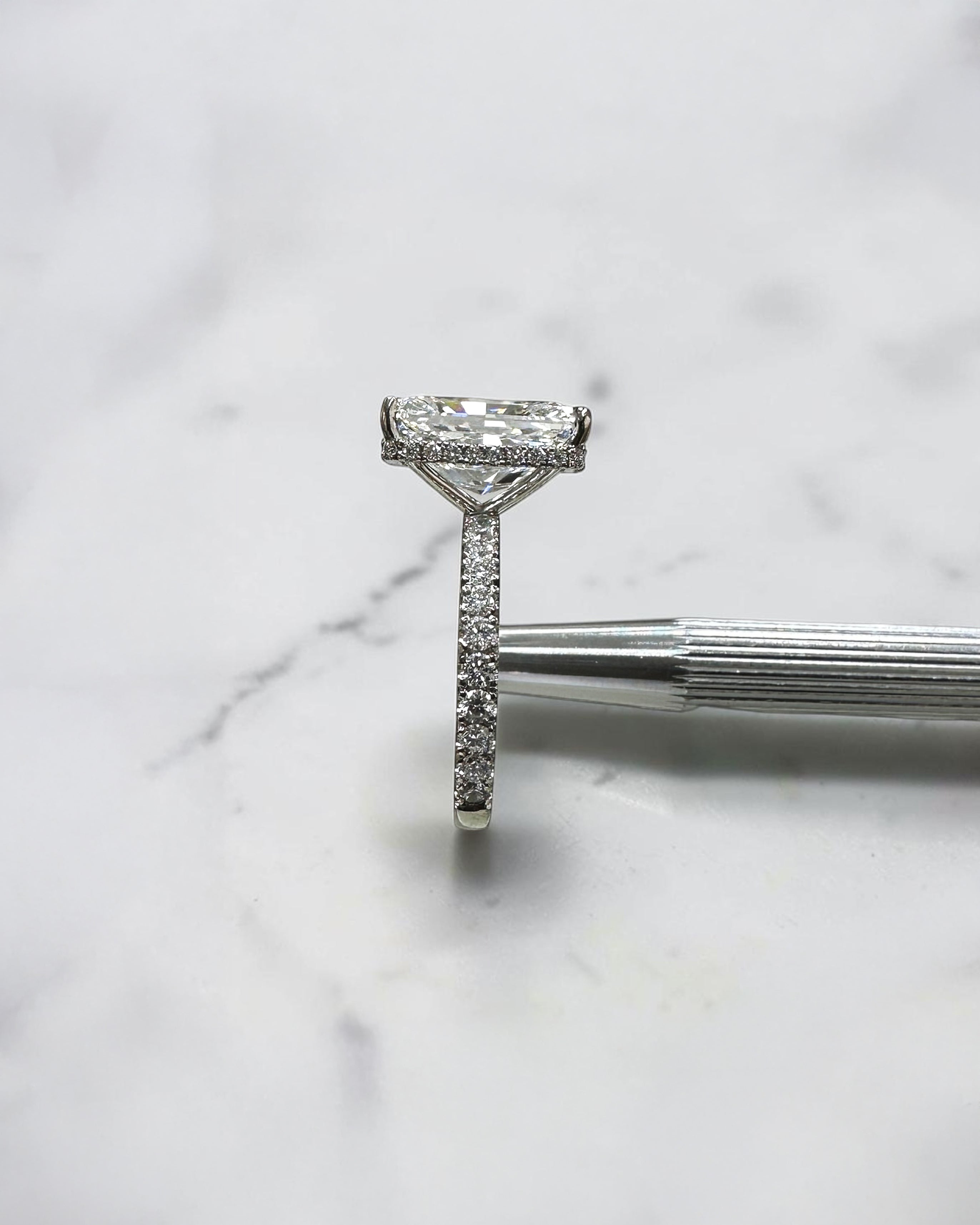 7ct radiant cut lab grown diamond engagement ring with diamond shoulder band, floating setting and wrap around hidden halo, handmade in London.