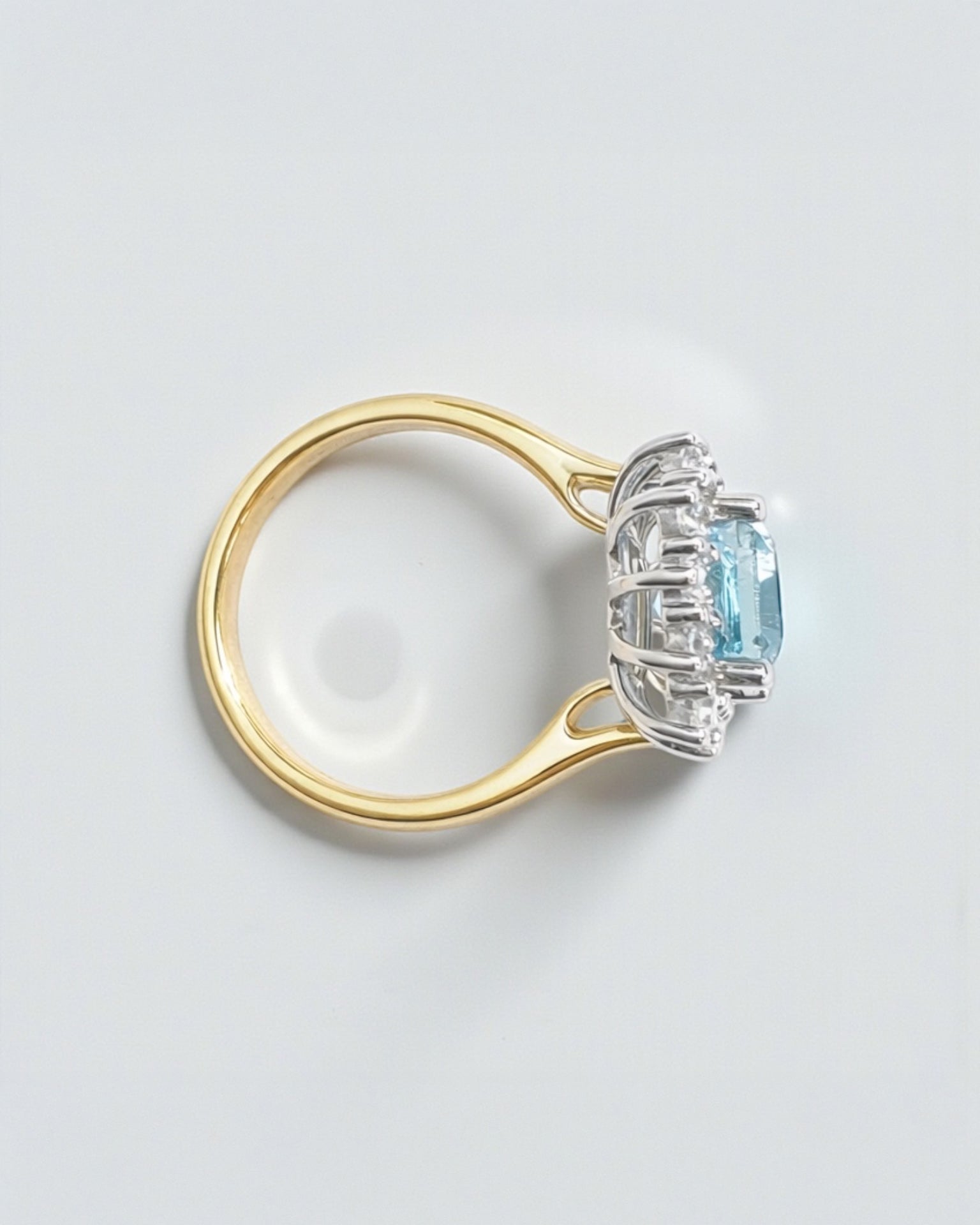 Emerald cut aquamarine and diamond halo ring in 18kt yellow gold with platinum basket