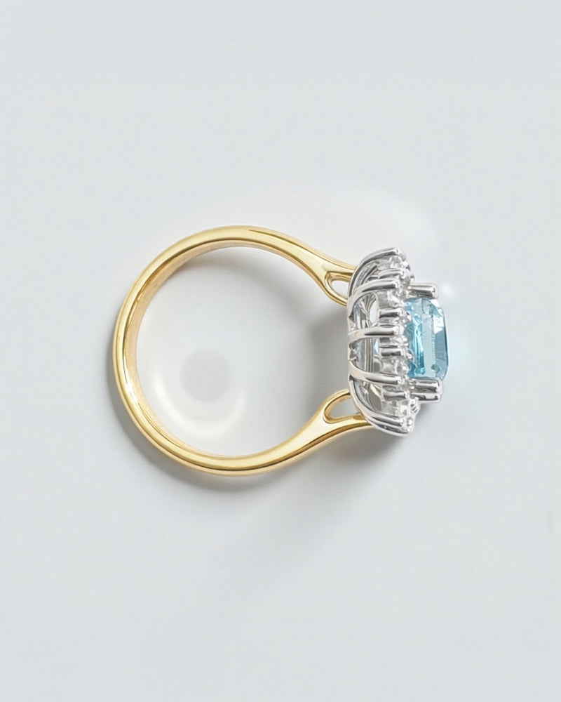 Emerald cut aquamarine and diamond halo ring in 18kt yellow gold with platinum basket