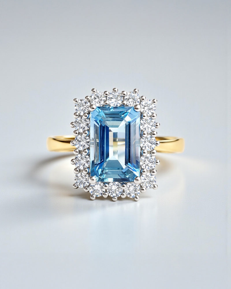 Emerald cut aquamarine and diamond halo ring in 18kt yellow gold with platinum basket
