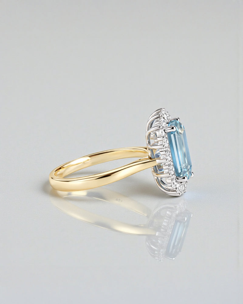 Emerald cut aquamarine and diamond halo ring in 18kt yellow gold with platinum basket
