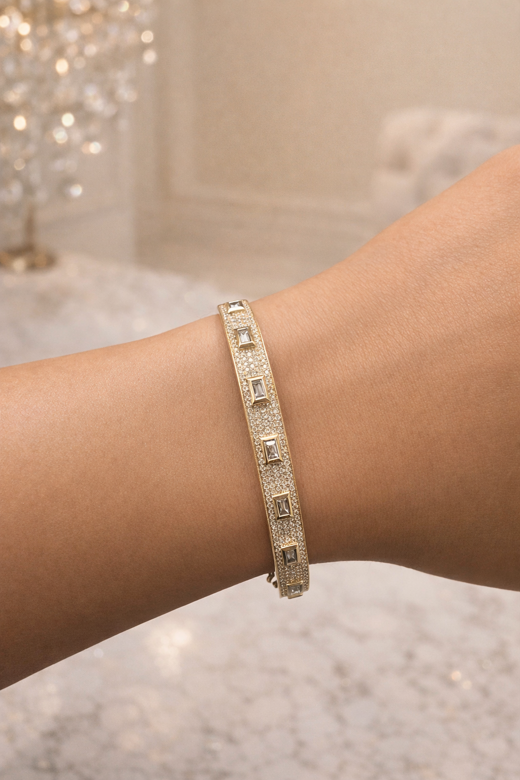 Diamond bangle in yellow gold with baguette and round brilliant cut diamonds on wrist, hand 