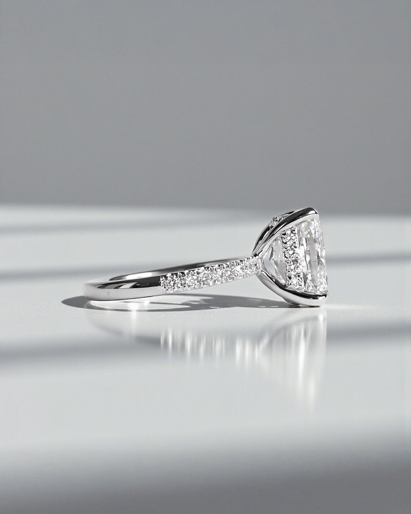 4ct cushion cut lab grown diamond engagement ring with diamond shoulders and hidden halo. Available in 18ct white, yellow, rose gold or platinum.