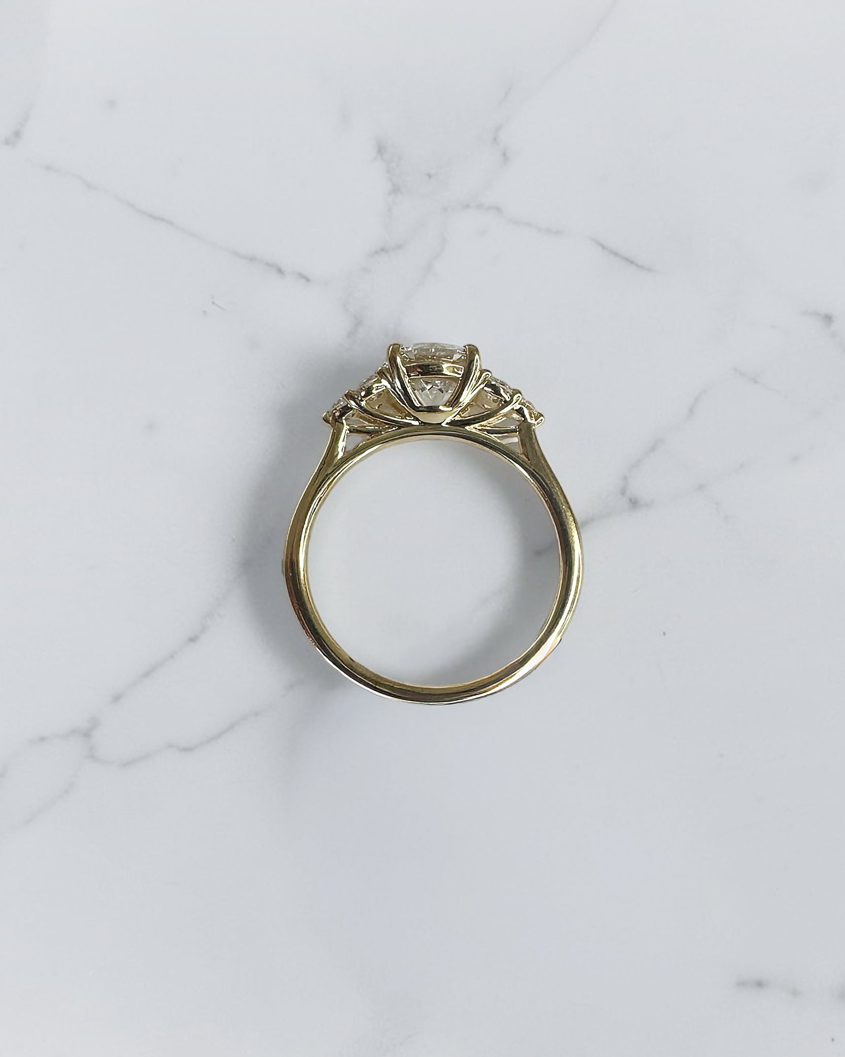 1.50ct round brilliant lab grown diamond trefoil engagement ring with diamond cluster shoulders in yellow gold.