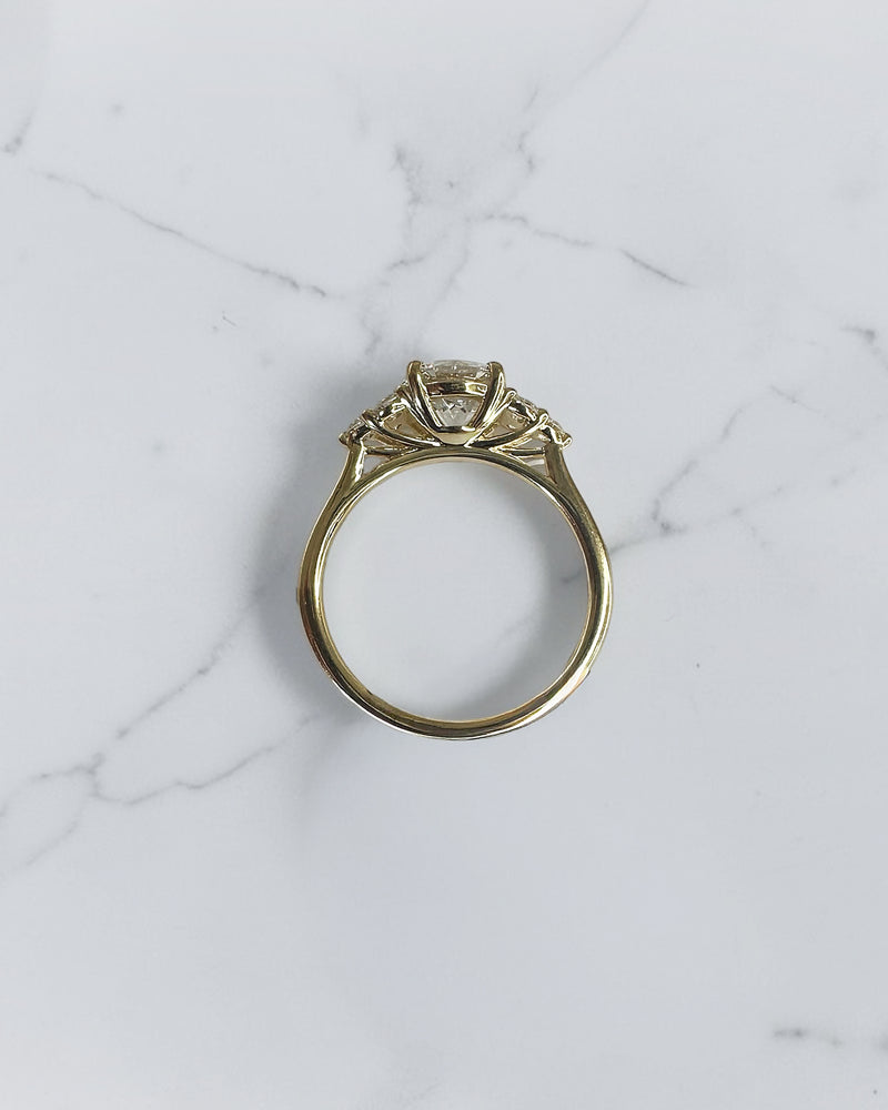 1.50ct round brilliant lab grown diamond trefoil engagement ring with diamond cluster shoulders in yellow gold.