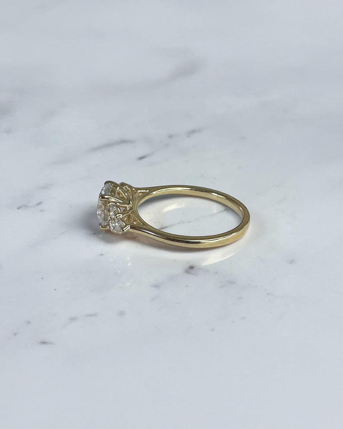 1.50ct round brilliant lab grown diamond trefoil engagement ring with diamond cluster shoulders in yellow gold.