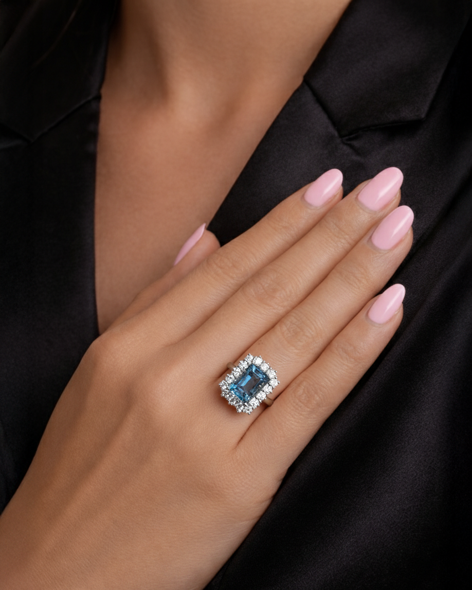 Emerald cut aquamarine and diamond halo ring in 18kt yellow gold with platinum basket