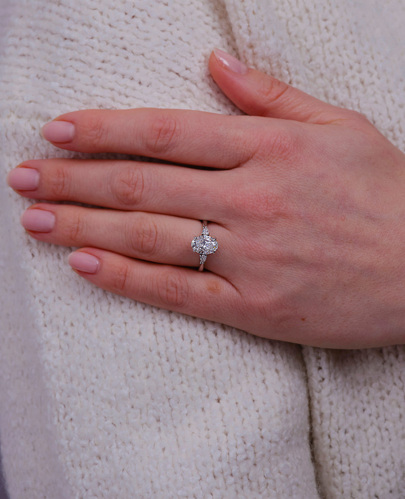 2ct oval cut lab grown diamond trilogy engagement ring on hand with pear cut side diamonds by Layla Diamonds.
