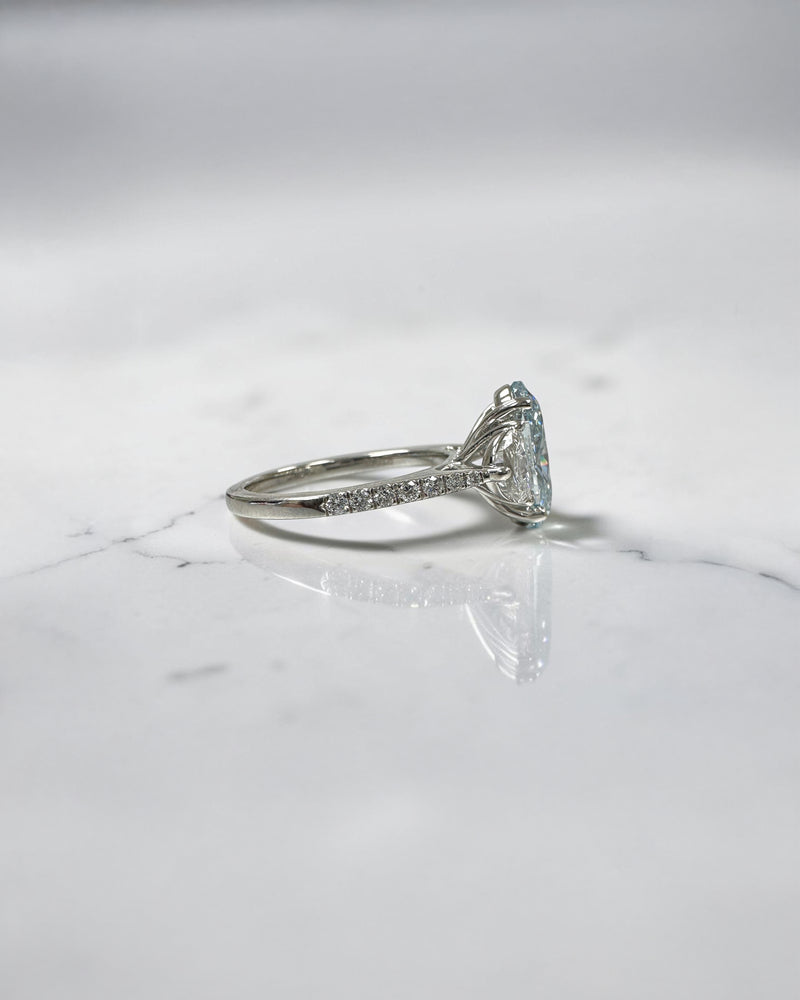 3.70ct baby fancy blue oval cut lab grown diamond trilogy engagement ring with half moon side stones and diamond set tapered shoulders in platinum setting 