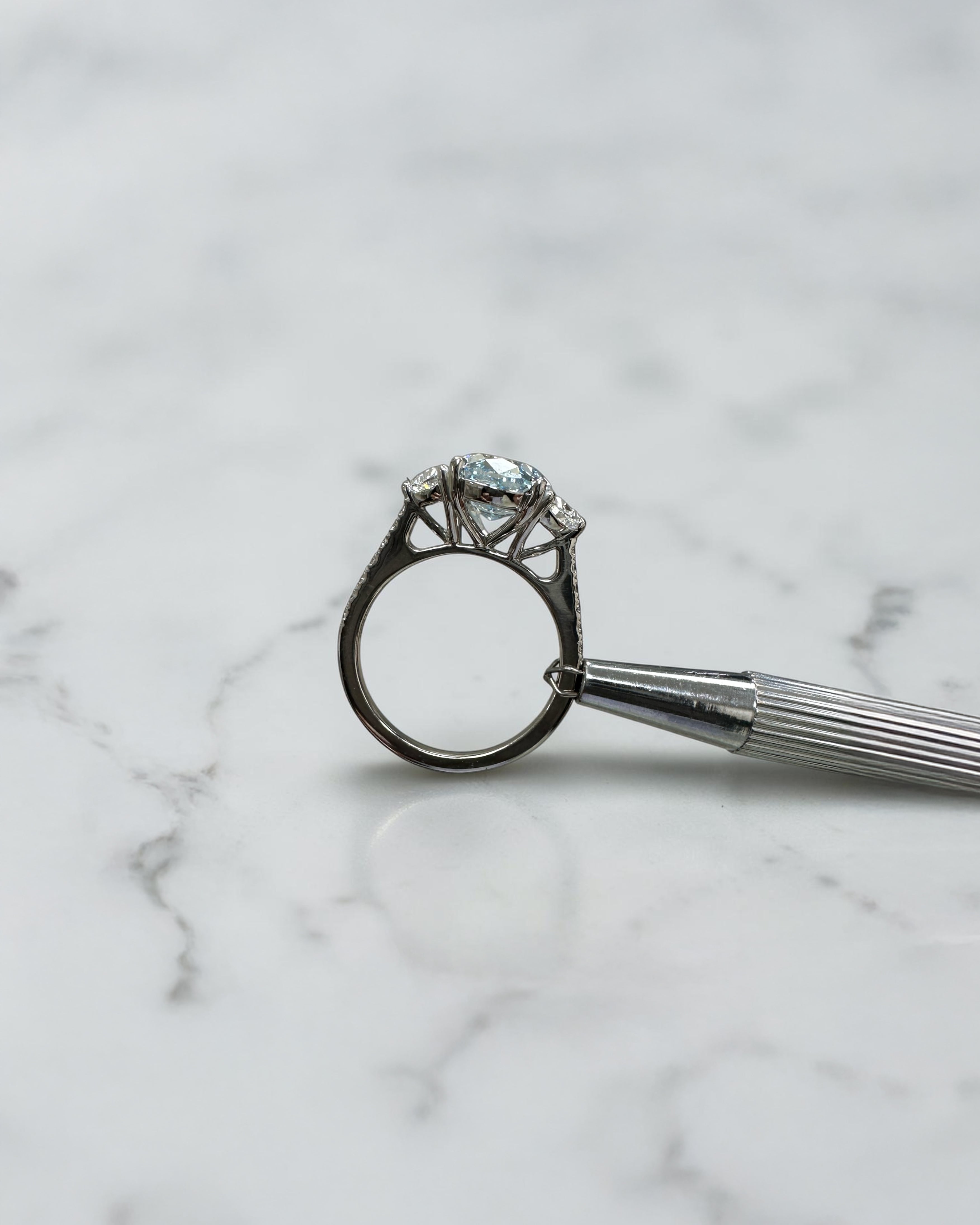 3.70ct baby fancy blue oval cut lab grown diamond trilogy engagement ring with half moon side stones and diamond set tapered shoulders in platinum setting 