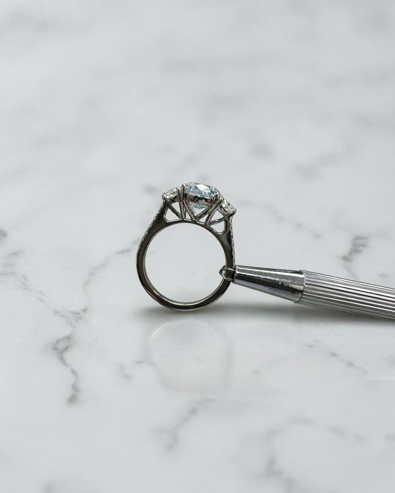 3.70ct baby fancy blue oval cut lab grown diamond trilogy engagement ring with half moon side stones and diamond set tapered shoulders in platinum setting 
