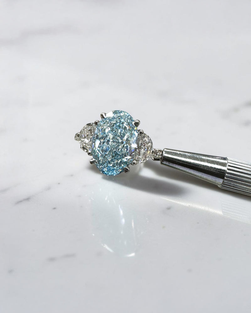 3.70ct baby fancy blue oval cut lab grown diamond trilogy engagement ring with half moon side stones and diamond set tapered shoulders in platinum setting 