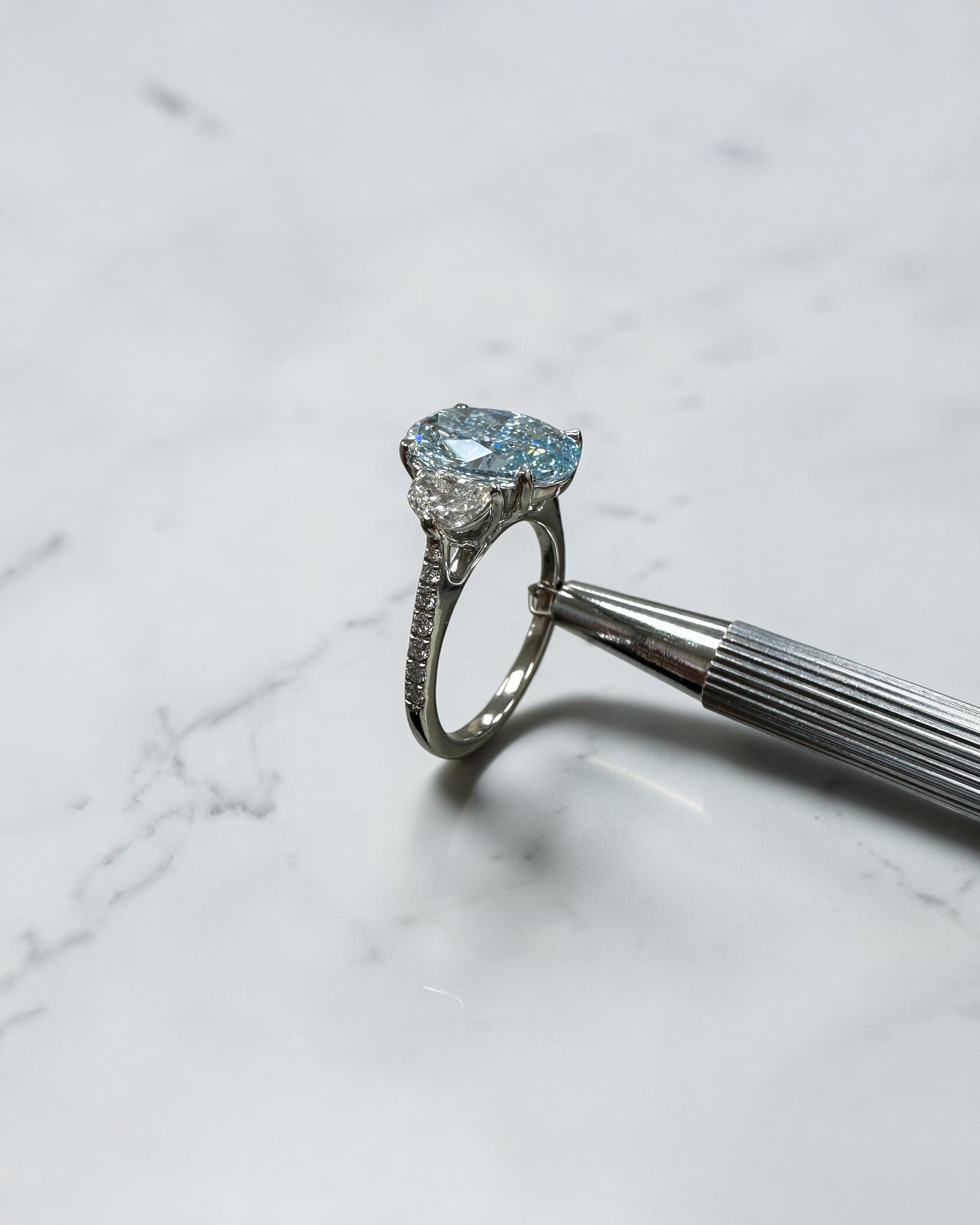 3.70ct baby fancy blue oval cut lab grown diamond trilogy engagement ring with half moon side stones and diamond set tapered shoulders in platinum setting 