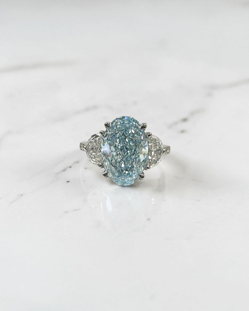 3.70ct baby fancy blue oval cut lab grown diamond trilogy engagement ring with half moon side stones and diamond set tapered shoulders in platinum setting 