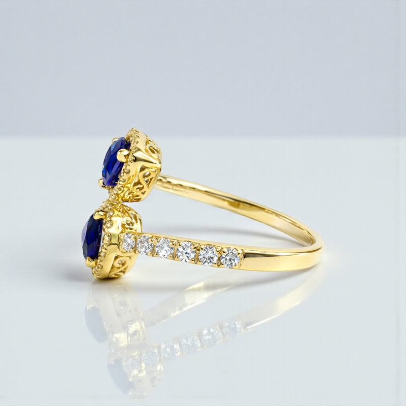 Two stone pear cut blue sapphire and diamond halo ring in 18kt yellow gold