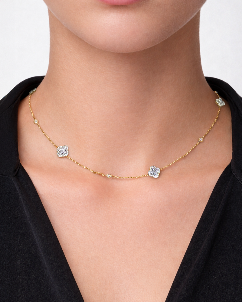 Clover motif diamond necklace in yellow gold with 1.40ct diamonds on an adjustable fine chain, worn on model neckline