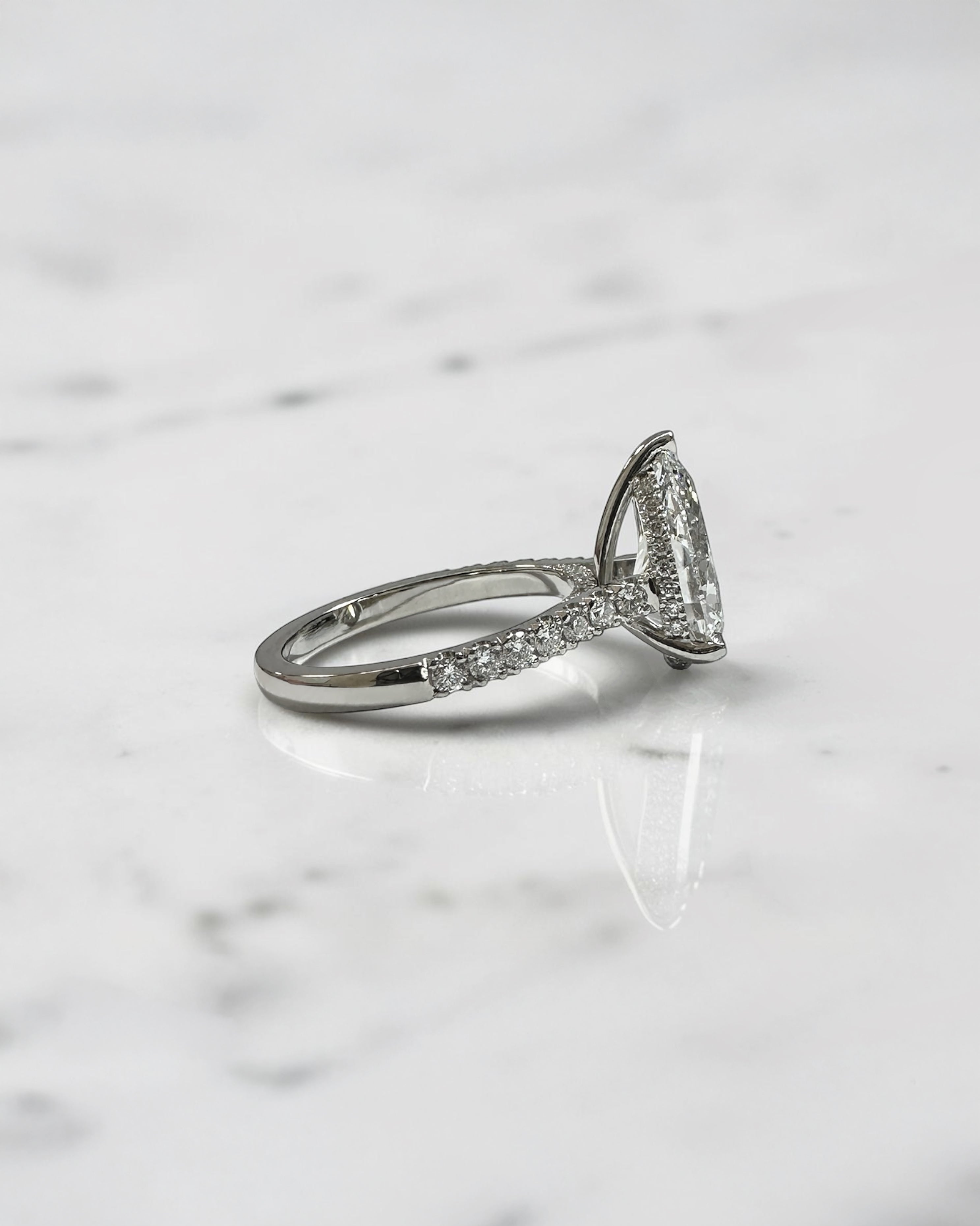 2ct pear cut lab grown diamond engagement ring with cathedral setting, diamond shoulder band, hidden halo and diamond bridge, handcrafted in platinum by Layla Diamonds.