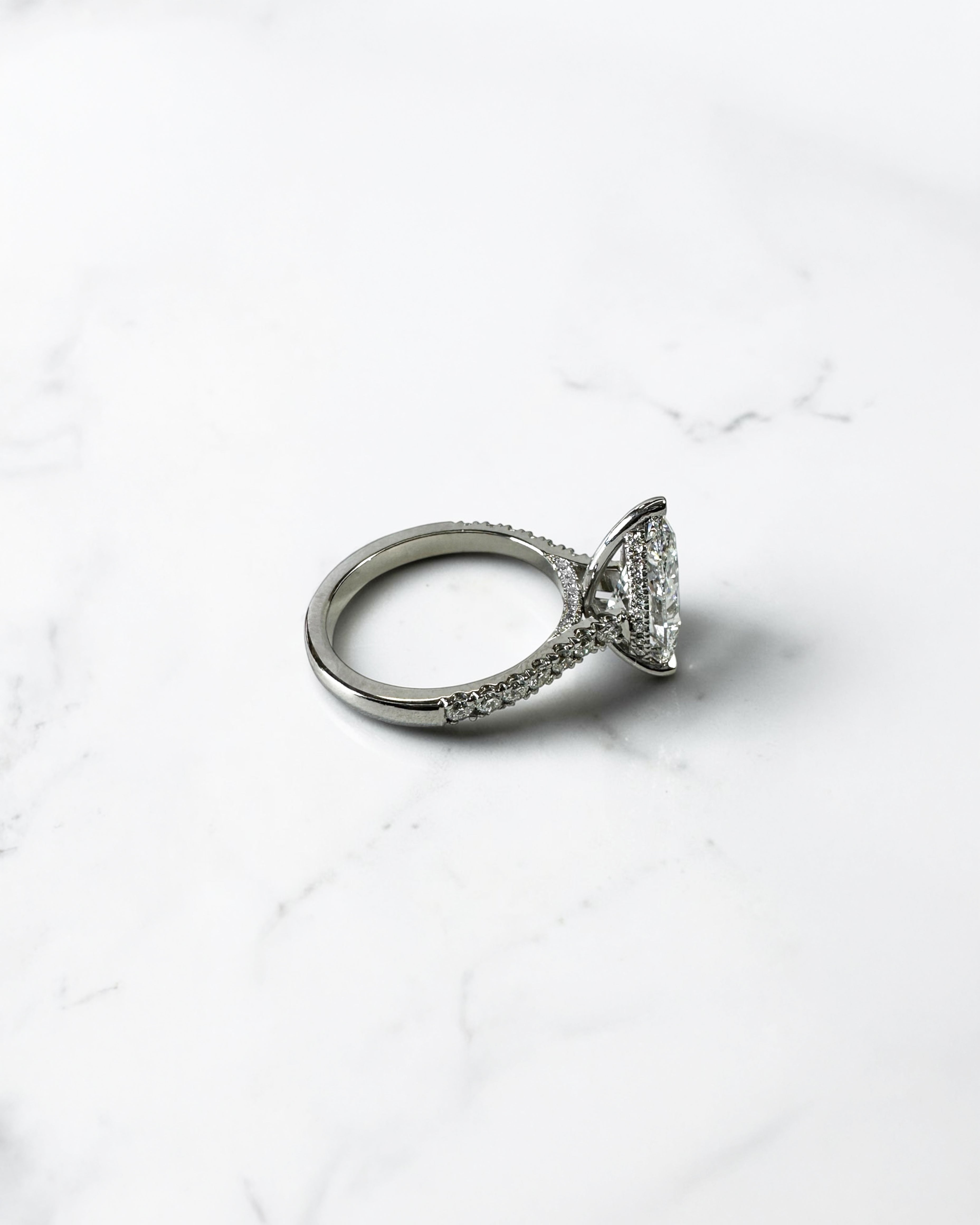 2ct pear cut lab grown diamond engagement ring with cathedral setting, diamond shoulder band, hidden halo and diamond bridge, handcrafted in platinum by Layla Diamonds.
