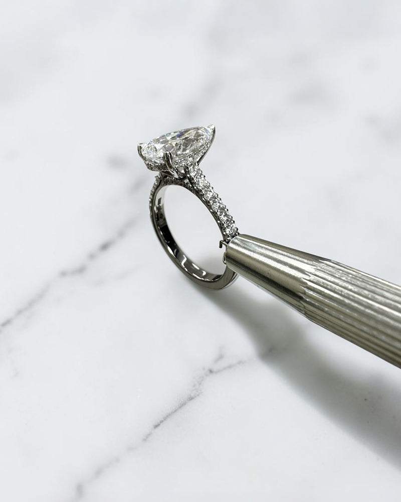 2ct pear cut lab grown diamond engagement ring with cathedral setting, diamond shoulder band, hidden halo and diamond bridge, handcrafted in platinum by Layla Diamonds.