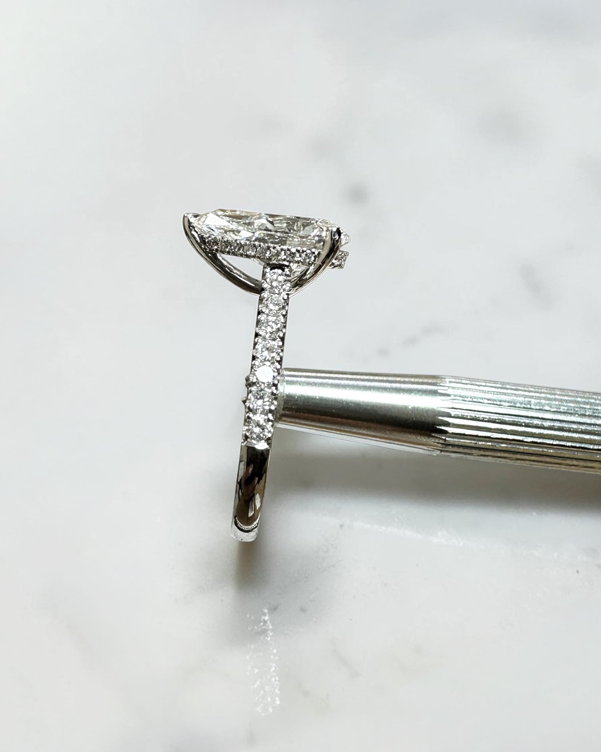 2ct pear cut lab grown diamond engagement ring with cathedral setting, diamond shoulder band, hidden halo and diamond bridge, handcrafted in platinum by Layla Diamonds.
