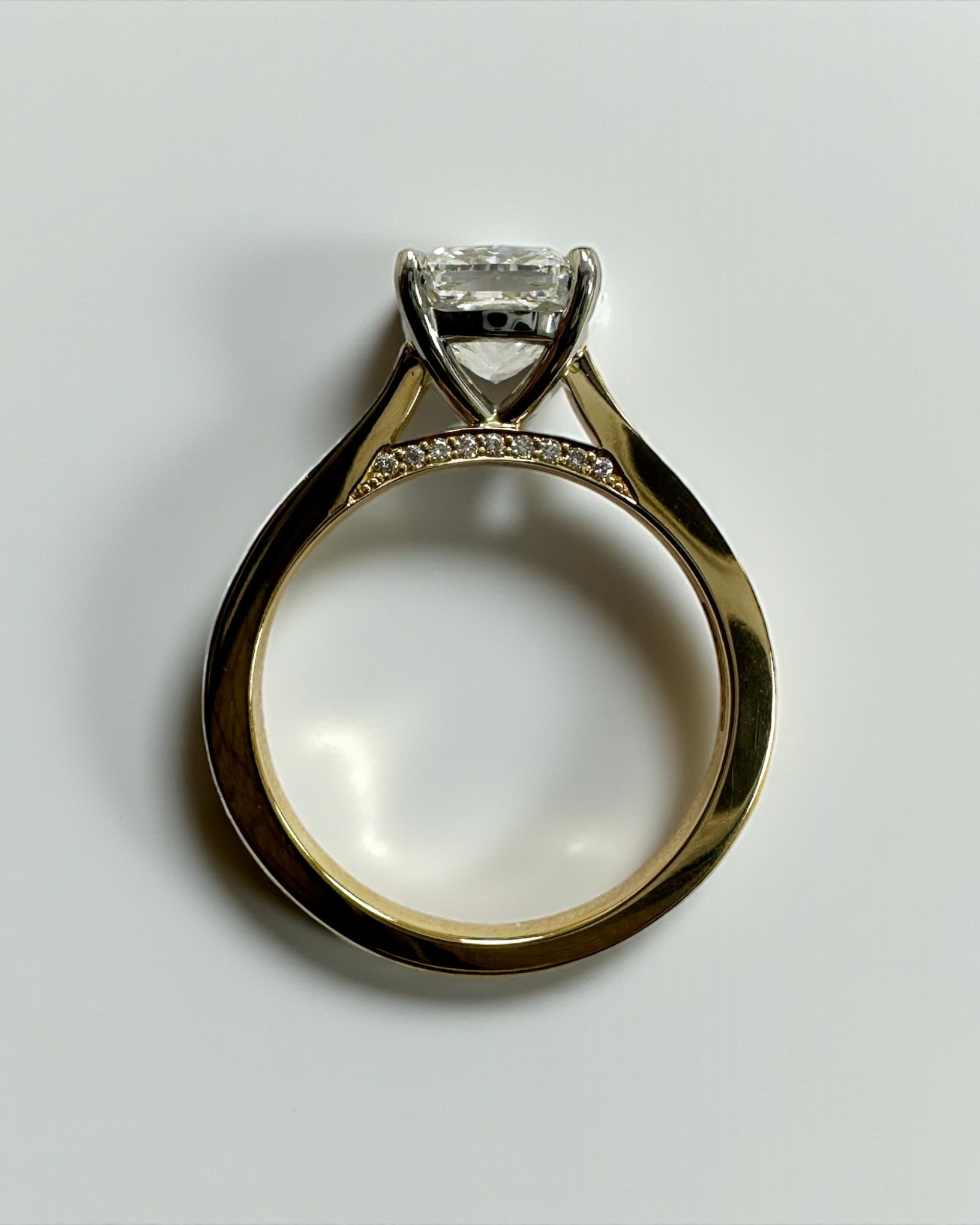 Two tone cushion cut diamond engagement ring, featuring platinum head and channel set band 18kt yellow gold by Layla Diamonds