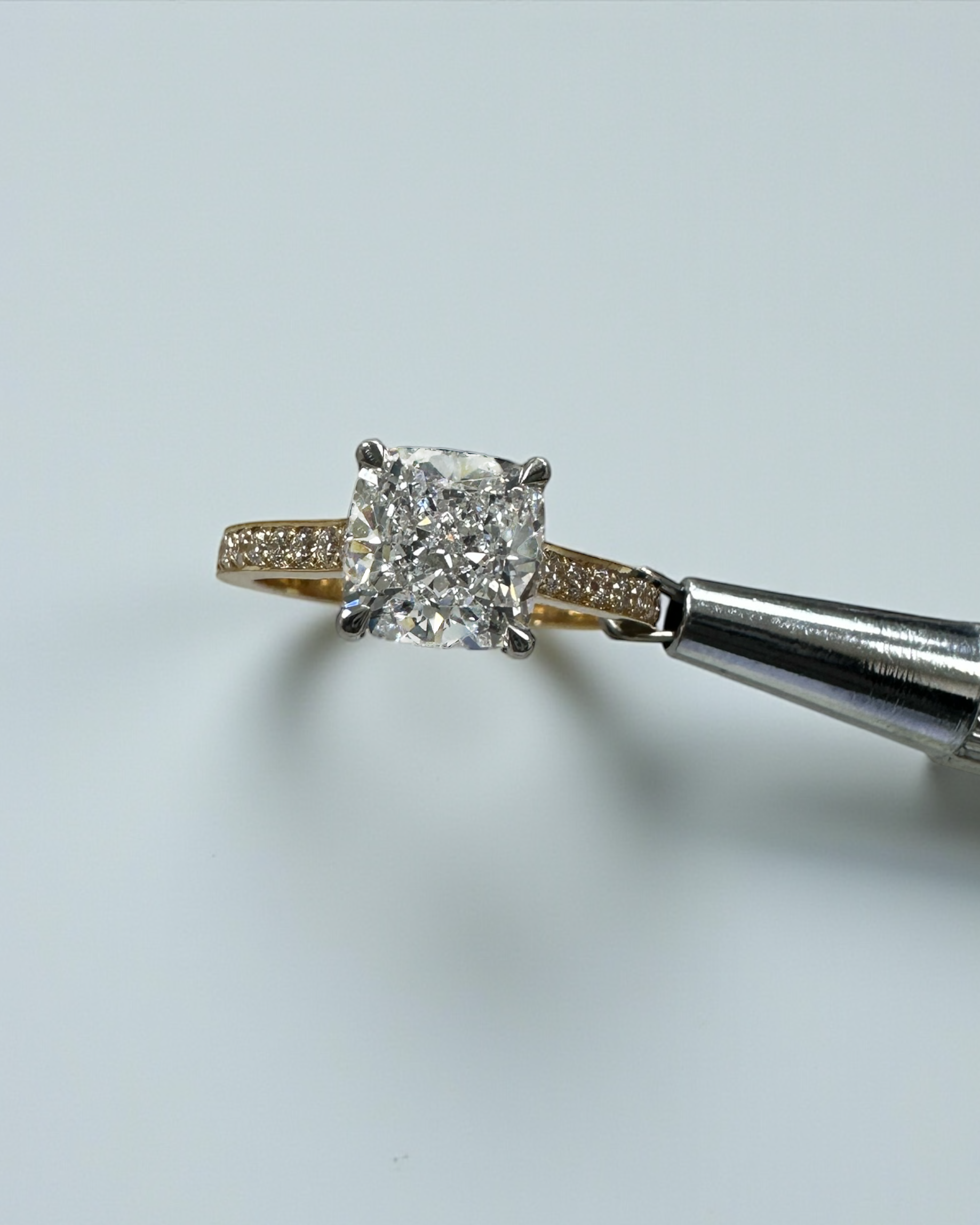 Two tone cushion cut diamond engagement ring, featuring platinum head and channel set band 18kt yellow gold by Layla Diamonds