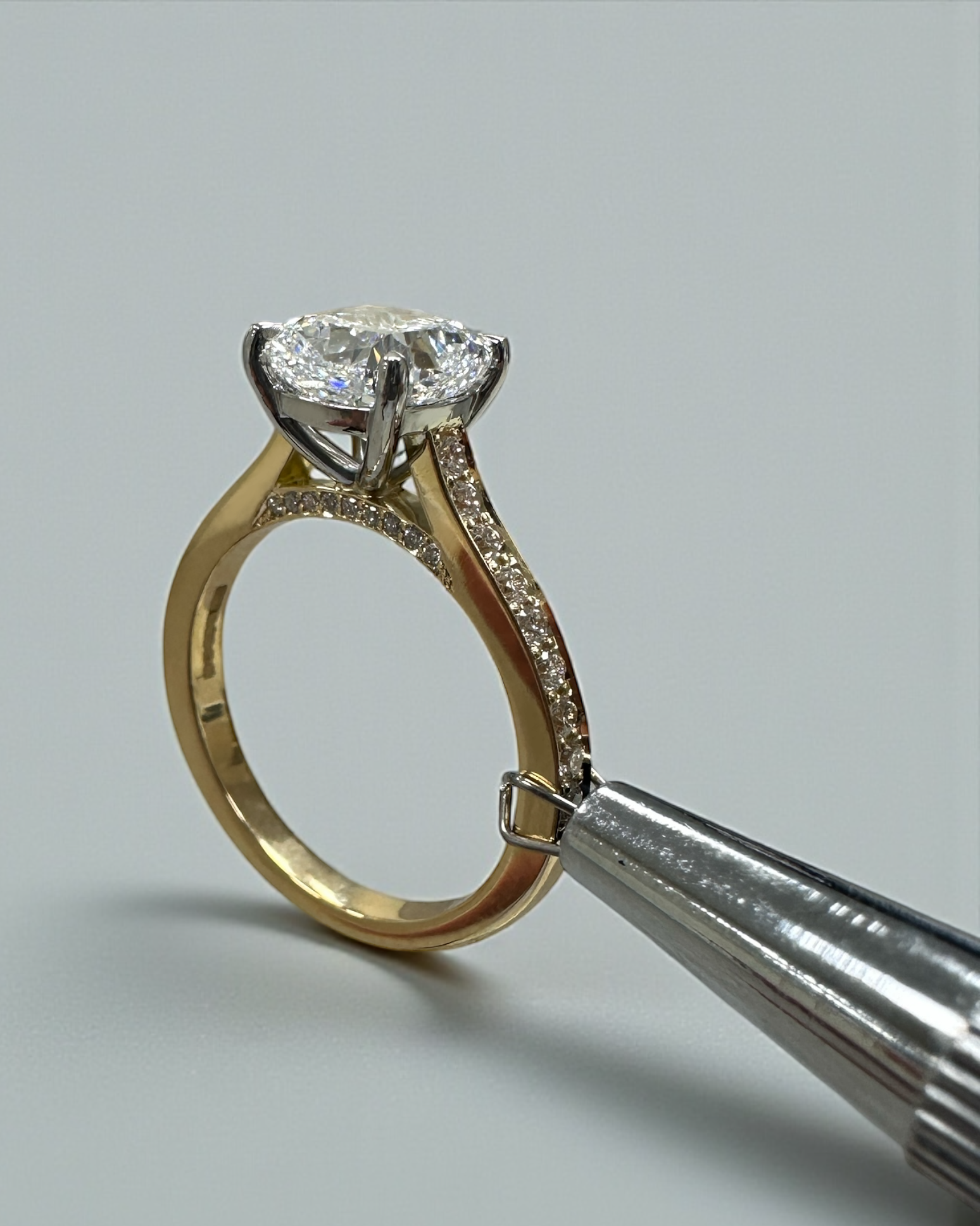 Two tone cushion cut diamond engagement ring, featuring platinum head and channel set band 18kt yellow gold by Layla Diamonds