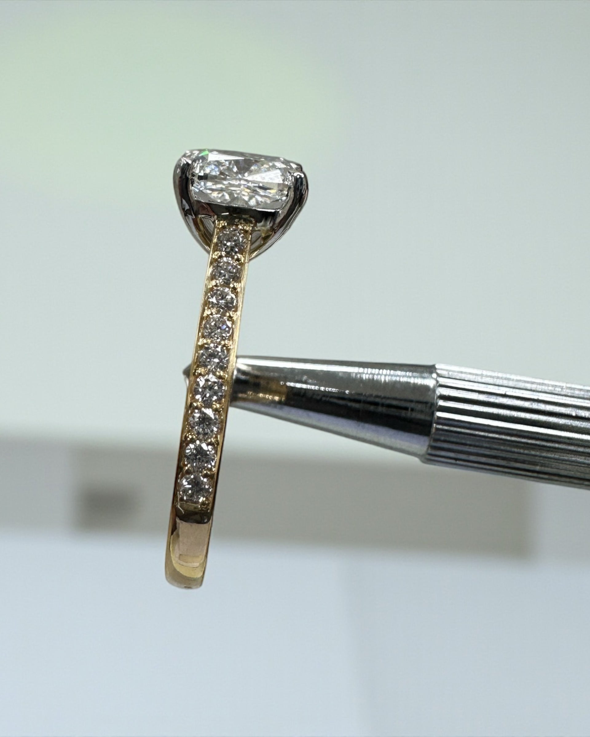 Two tone cushion cut diamond engagement ring, featuring platinum head and channel set band 18kt yellow gold by Layla Diamonds