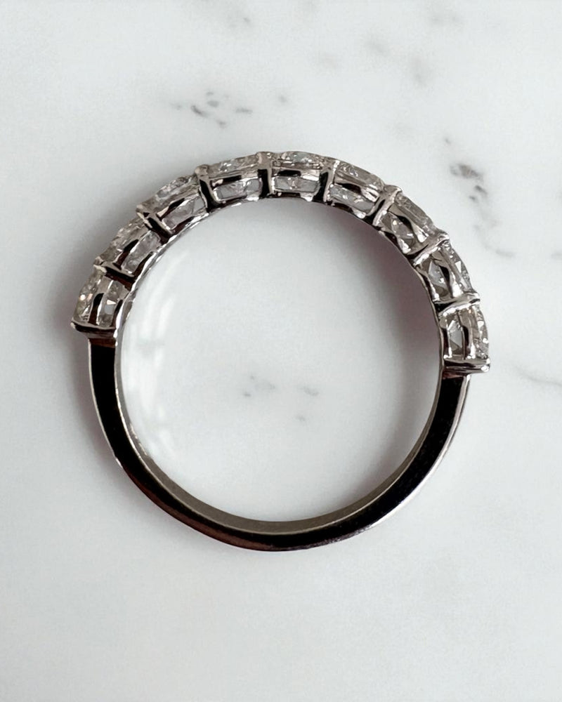 1.50ct round diamond half eternity band worn on a finger, showcasing a classic diamond engagement band design.