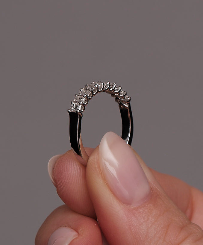 Mini emerald cut diamond band worn on a finger, showcasing a sophisticated and modern design.