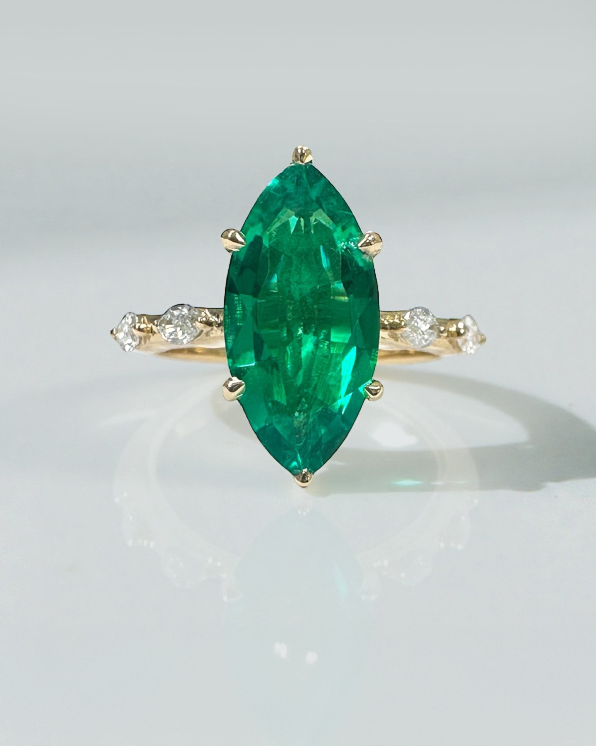 2.40ct marquise cut lab grown green emerald engagement ring with marquise diamond shoulders and hidden halo in 18kt yellow gold
