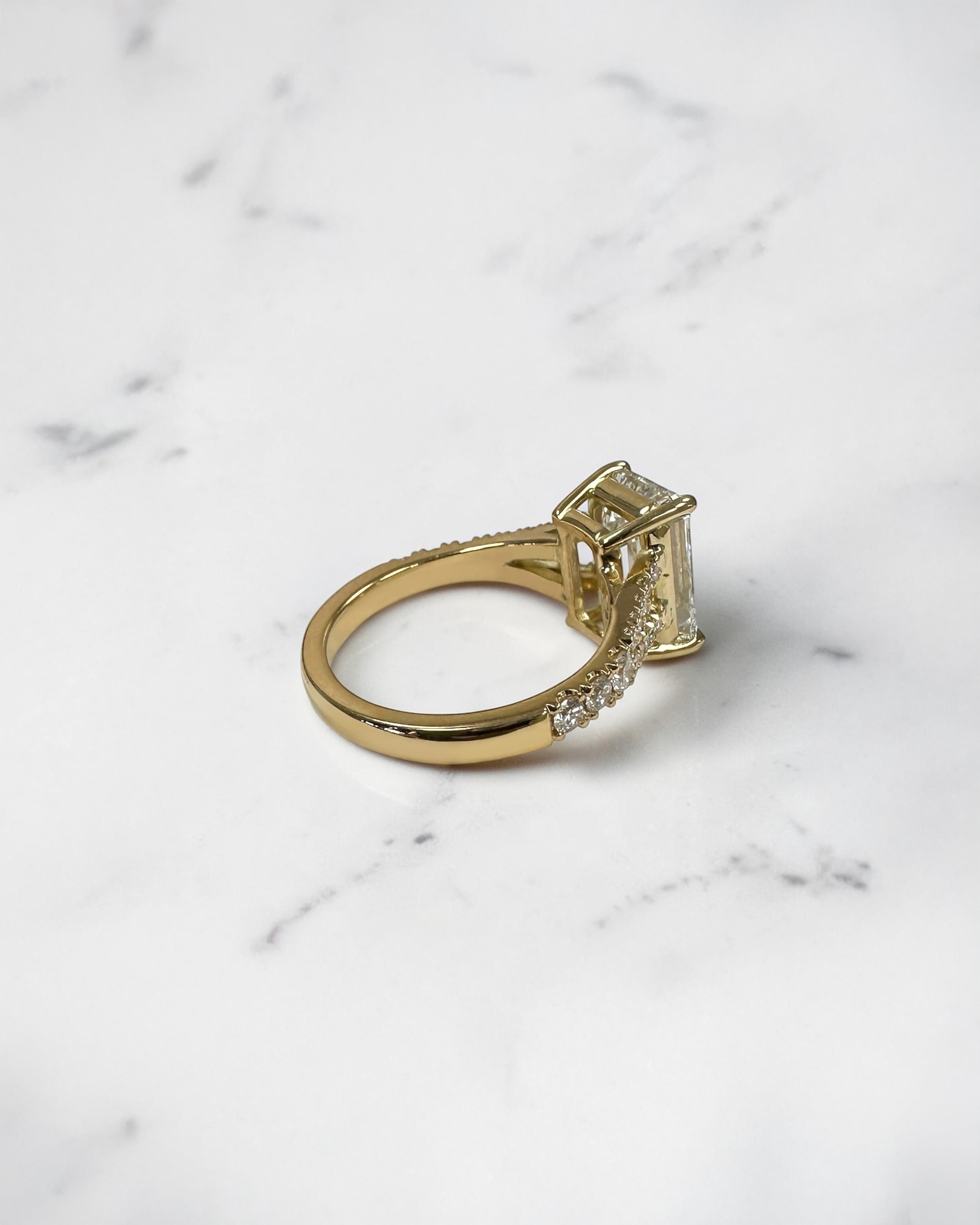 3ct emerald cut lab grown diamond engagement ring with a diamond split shank band, handcrafted in London and available in Platinum, 18ct yellow, white or rose gold.