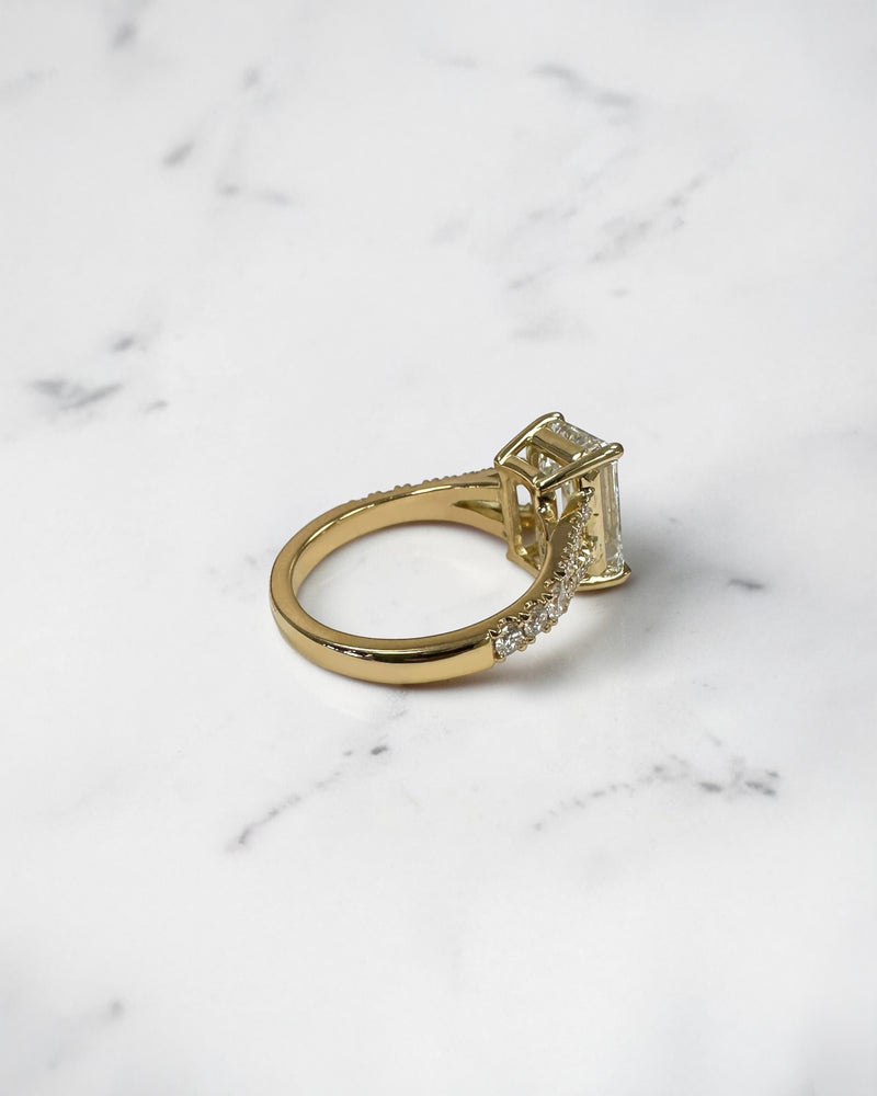3ct emerald cut lab grown diamond engagement ring with a diamond split shank band, handcrafted in London and available in Platinum, 18ct yellow, white or rose gold.